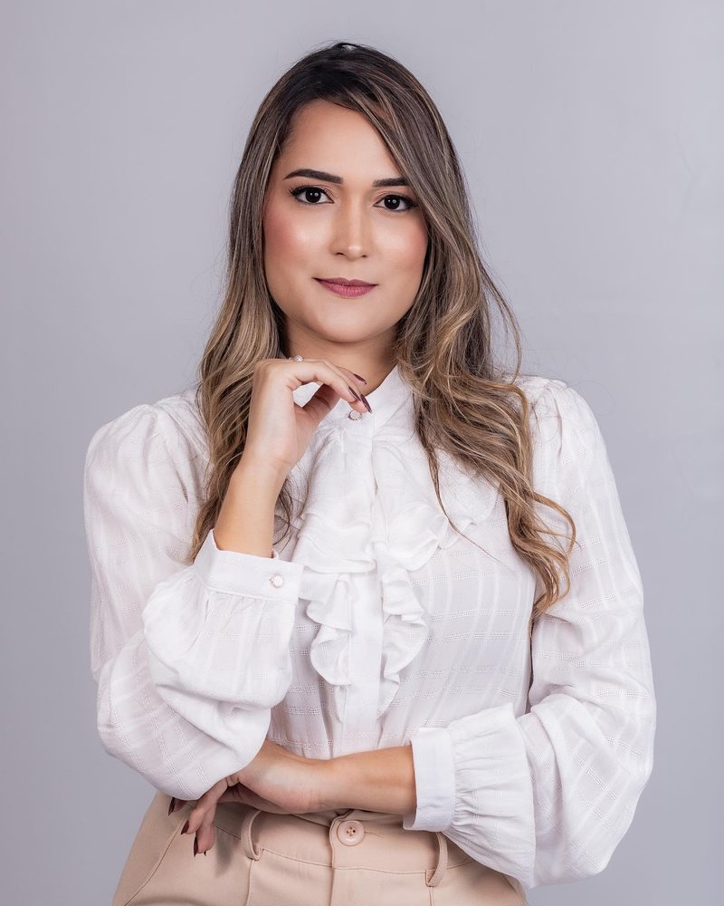 Retrato da advogada Maria Madalena, de blusa branca, em fundo claro